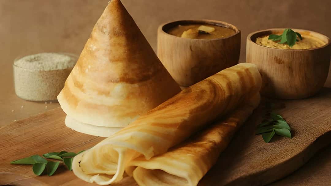 Millet dosas on a wooden chopping board